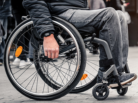 person in wheelchair crossing the road